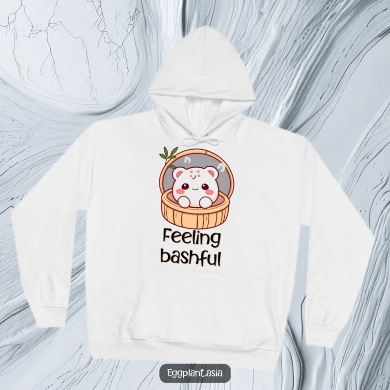 Funny shy, blushing bao bun character peeking from a bamboo steamer, depicted on a cozy hoodie.